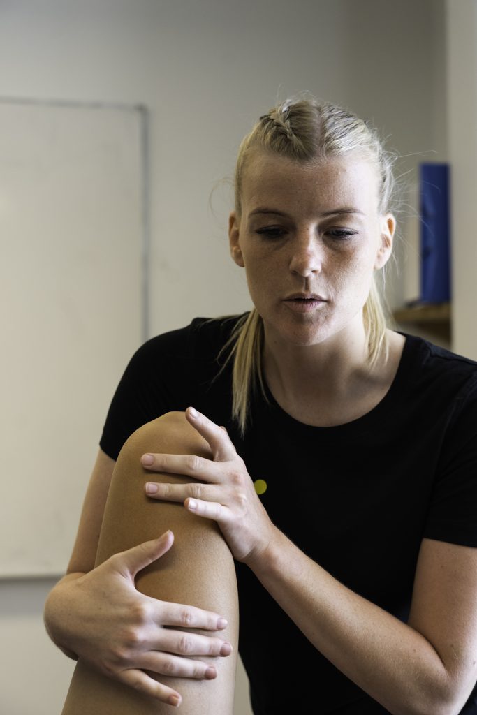 Osteopat fra Efficax undersøger en patients knæ, muligvis for at vurdere og behandle væske i knæet.