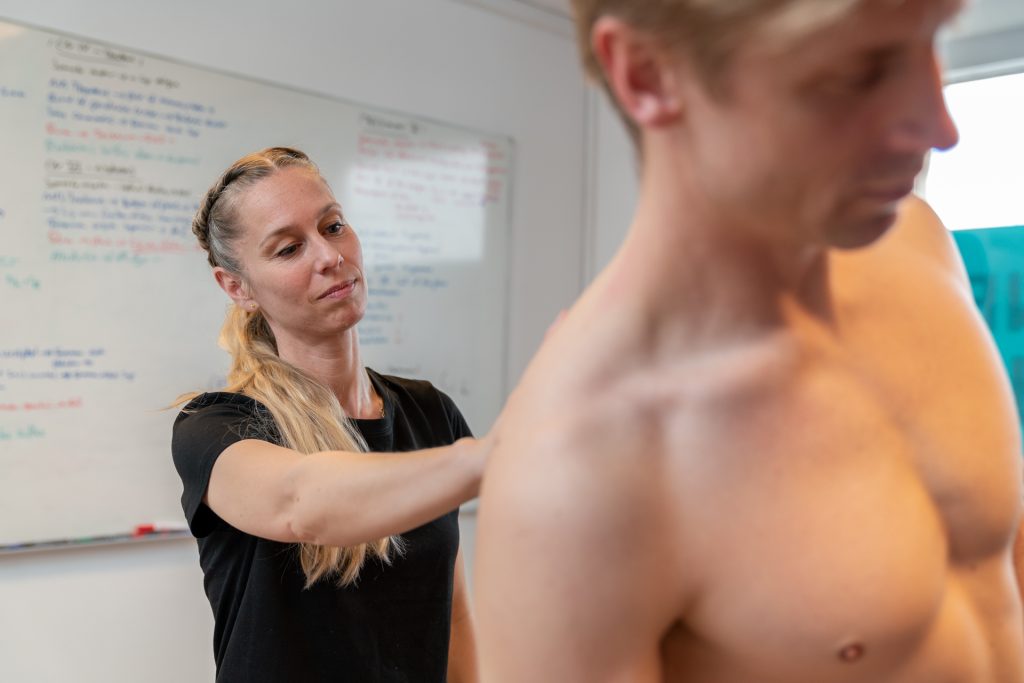 Osteopat udfører behandling af en klient med fokus på skulder og ryg.