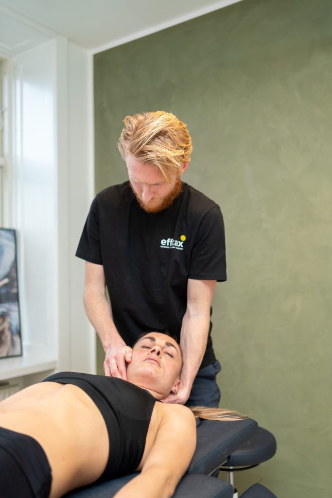 Behandler hos Efficax udfører nakke- og skuldermassage for at lindre spændinger og smerter.