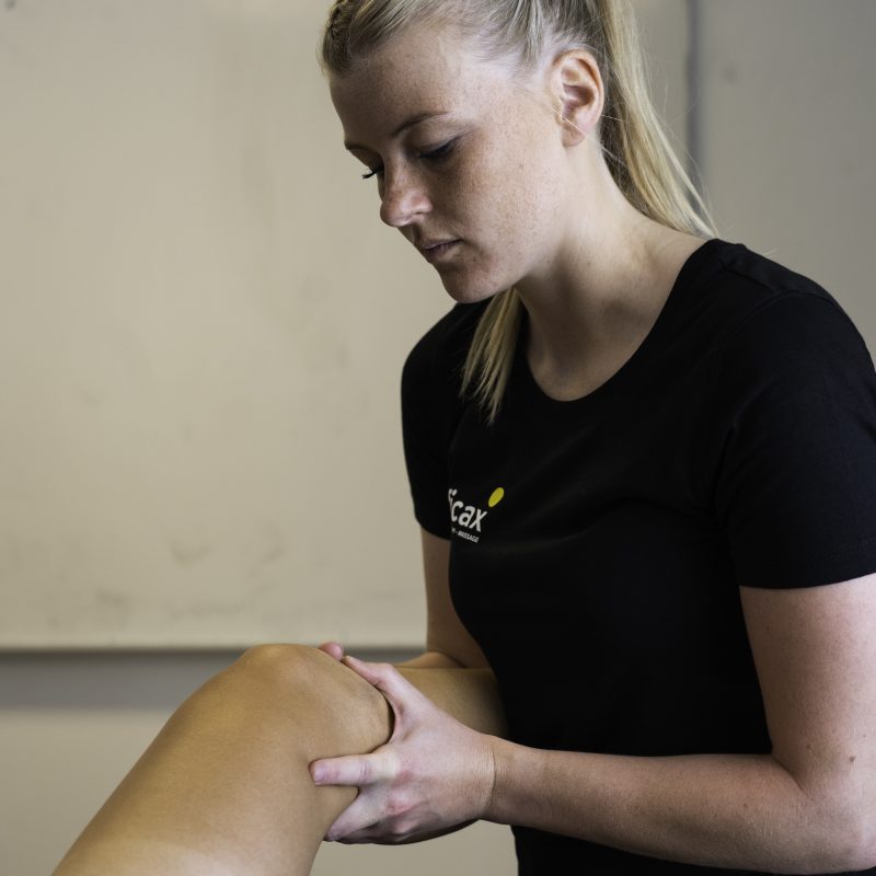 Osteopat fra Efficax undersøger en patients knæ, muligvis for at behandle væske i knæet.