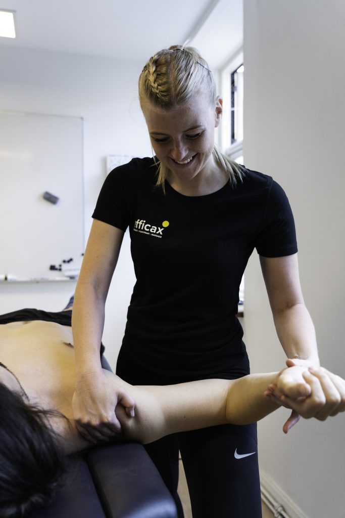 Behandler fra Efficax udfører manuel behandling af skulder for at reducere smerter og inflammation.